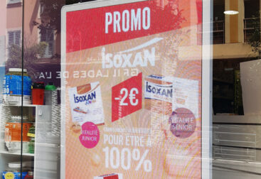 Photo de vitrine de pharmacie avec écran publicitaire vidéo Isoxan.